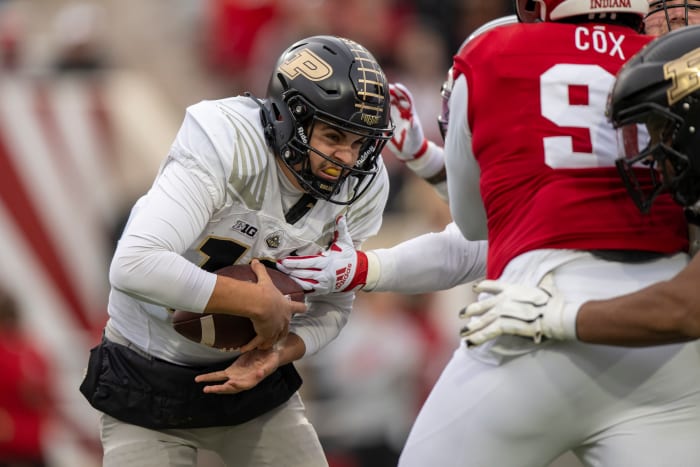 Aidan O’Connell runs with the ball tucked under one hand as Indiana defenders try to reach it